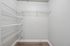 Spacious Walk In closet with sleek wire shelving, offering ample storage and organization in modern apartment.