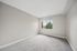 Bright and spacious bedroom with plush carpet and a large window offering a serene view.