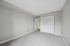 Bright and welcoming empty bedroom with plush carpet and ample closet space for storage.