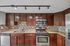 Modern kitchen showcasing sleek stainless steel appliances, elegant granite countertops, and rich wooden cabinetry with contemporary backsplash.