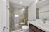 Modern bathroom with elegant glass shower enclosure, stylish vanity, and sleek fixtures.