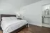 Bright and inviting bedroom with a spacious layout, polished wooden floors, and an en suite bathroom for modern comfort.