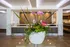 Elegant lobby with a striking floral arrangement in a modern white planter, complemented by sleek wooden paneling and ambient lighting.