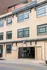 Charming historic brick building showcasing a classic architectural style with large industrial windows and convenient street-level parking entrance.