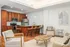 Modern apartment interior with open-concept kitchen and living area, featuring warm wood cabinetry, a stylish breakfast bar, and cozy seating.