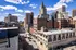Vibrant cityscape showcasing historic architecture and modern skyscrapers under a bright blue sky, ideal for urban living.