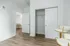 Bright and modern apartment interior with elegant white doors, spacious closet, and two plush bar stools, perfect for stylish living.