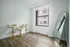 Modern minimalist room showcasing elegant bar stools, a sleek full-length mirror, and expansive natural light through a large window.