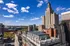 Stunning aerial view of a vibrant cityscape with iconic architecture under a clear blue sky, offering an upscale urban lifestyle.
