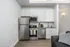 Modern kitchen showcasing sleek stainless steel appliances, white cabinetry, and elegant granite countertops in a stylish apartment setting.
