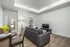 Modern living room with sleek gray sofa, elegant lamp, contemporary art, and cozy dining nook, perfect for stylish relaxation.