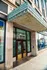 Historic building entrance with ornate architectural details and large glass windows on a bustling city street.