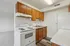 Cozy kitchen with wooden cabinets, electric stove, and white countertops.