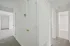 Bright hallway in modern apartment with carpet flooring and white doors.