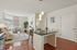 Modern apartment living room with open floor plan, sleek kitchen island, and abundant natural light.
