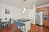 Modern kitchen and dining space with sleek stainless steel appliances, stylish pendant lighting, and a cozy dining area.