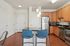 Inviting kitchen with elegant cabinetry, stainless steel appliances, and a chic breakfast bar with stylish seating.