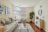 Inviting living room with modern decor, plush sofa, large window, and stylish accents.