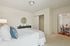 Inviting bedroom with modern decor, plush bedding, and an adjoining dining area, perfect for cozy living.