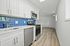 Modern kitchen with sleek white cabinetry, vibrant blue subway tiles, and stainless steel appliances, creating an inviting culinary space.