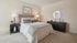 Elegant bedroom with plush king-sized bed, stylish decor, and natural light creating a cozy retreat.