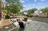 Inviting outdoor patio with modern seating surrounded by lush greenery, perfect for relaxation and social gatherings.