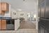 Inviting apartment entry featuring a modern open kitchen, elegant dining area, and a cozy living space leading to a serene bedroom.