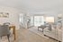 Inviting living space with an open floor plan, featuring a cozy living room, elegant dining area, and natural light streaming through expansive windows.