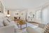 Inviting living and dining area with plush seating, chic decor, and natural light streaming through large windows.