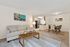 Inviting open-concept living area with cozy beige sofa, stylish coffee table, and modern dining space adjacent to a sleek kitchen with wood cabinetry.