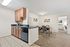 Charming open-concept apartment with a modern kitchen and cozy dining area, leading into a welcoming bedroom, perfect for comfortable living.