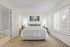 Inviting bedroom with a plush bed, soft lighting, and a serene bathroom entrance, perfect for relaxation.