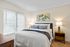 Bright and cozy bedroom with modern decor, featuring a comfortable bed, stylish artwork, and ambient lighting.