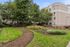 Charming apartment exterior with lush green pathways and beautifully landscaped gardens offering a serene escape.