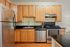 Charming kitchen with sleek stainless steel appliances, elegant wooden cabinets, and stylish black countertops.