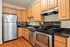 Modern kitchen with sleek stainless steel appliances, elegant wooden cabinetry, and polished countertops offering a perfect blend of functionality and style.