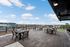 Spacious rooftop terrace with stylish seating offering stunning city views under a bright blue sky.