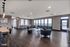 Modern and spacious community room featuring sleek furnishings, elegant lighting, and expansive windows with a view of the cityscape.