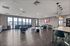 Spacious and modern apartment lounge with floor-to-ceiling windows, stylish seating, and elegant lighting, offering a vibrant city view for a perfect gathering space.