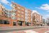 Contemporary urban apartment building with stylish brick facade and large windows, offering modern living spaces and easy access to city amenities.