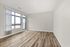 Bright and spacious empty room with large windows and elegant wood flooring, perfect for customization.