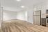 Bright open-plan living space with modern wood flooring, sleek kitchen appliances, and elegant cabinetry.