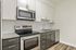 Modern kitchen with sleek stainless steel appliances, stylish granite countertops, and elegant cabinetry offering ample storage space.