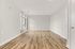 Bright and spacious living room with elegant wood flooring and large windows, perfect for relaxing and entertaining.