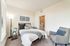 Cozy bedroom with stylish decor, soft lighting, and an en-suite bathroom, creating a serene and inviting atmosphere.