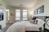Bright and cozy bedroom with modern decor, featuring elegant wall art, a plush bed, and large windows providing abundant natural light.