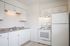 Bright and modern kitchen with sleek white cabinetry, granite countertops, and contemporary appliances.