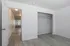 Bright and spacious room featuring sleek laminate flooring, an open closet, and a welcoming hallway with natural light.