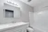 Bright, modern bathroom with sleek white countertop, elegant fixtures, and spacious shower, perfect for a refreshing start to your day.