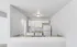 Modern kitchen with sleek white cabinetry, granite countertops, and a classic white appliance suite, offering a bright and inviting space.